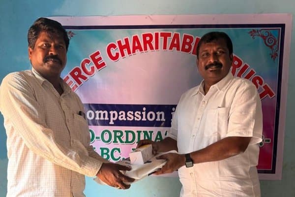 MCT leaders exchanging supplies in front of the MERCE Charitable Trust banner