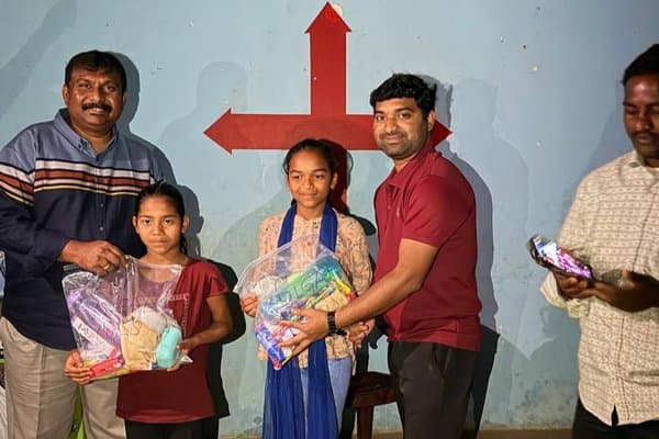 Two girls receiving personalised care kits from MCT volunteers
