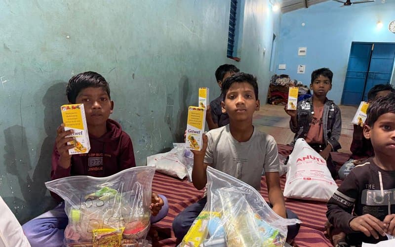 Children receiving nutrition supplements and healthcare packages at a MERCE camp