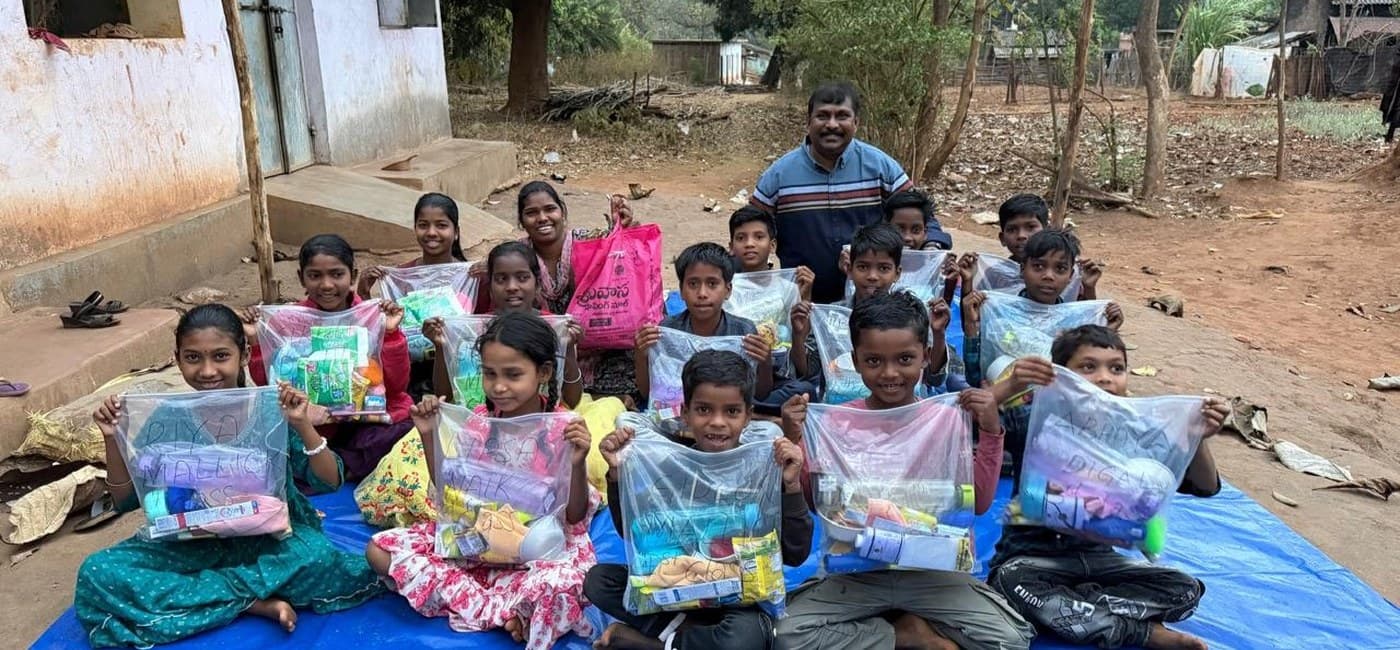Children from a tribal community proudly holding their named care packages at a MERCE Charitable Trust outreach event