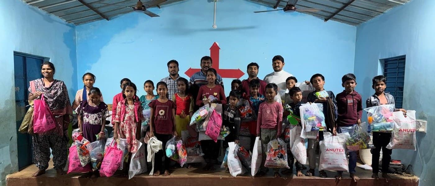 MCT leader addressing children during an outdoor community distribution event in a tribal area